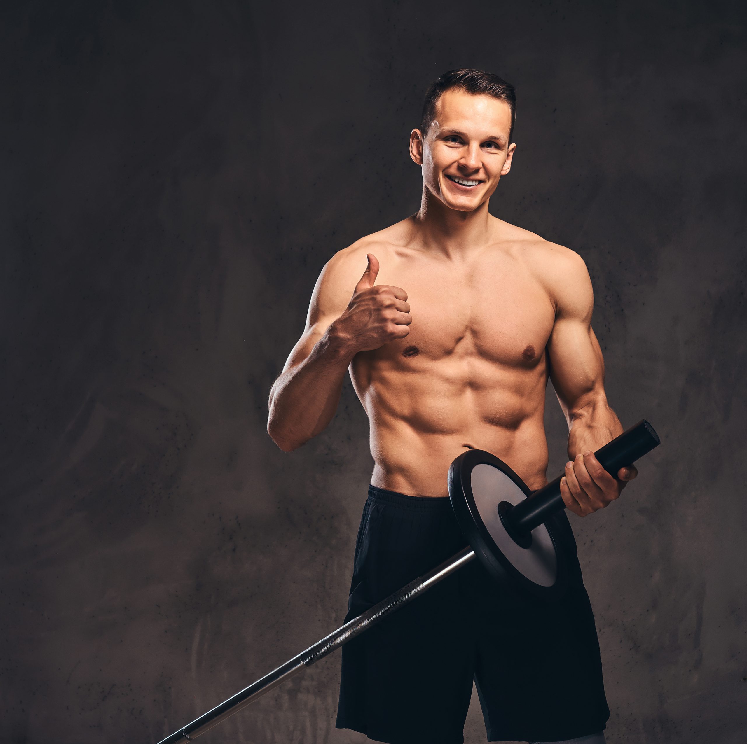 portrait of a handsome young bodybuilder on dark background.
